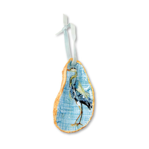 Decoupage oyster shell ornament with an ink and wash heron on blue linen ground and pale blue ribbon by Melissa Fouts