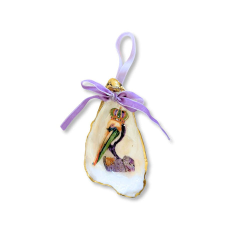 Decoupage oyster shell ornament with a crowned pelican in Mardi Gras purple, gilded rim, and lavender velvet ribbon by Melissa Fouts.