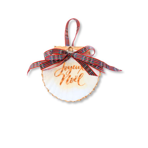 Decoupage scallop shell ornament with Joyeux Noël in gold script, gilded edge, and red plaid ribbon by Melissa Fouts.