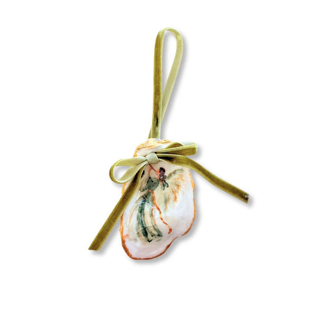 Decoupage oyster shell ornament with a green-robed angel playing a trumpet, gilded rim, and sage velvet ribbon by Melissa Fouts.