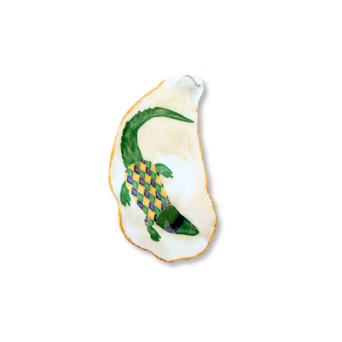 Decoupage oyster shell dish with a green alligator in a purple, green, and gold harlequin pattern and a gilded rim by Melissa Fouts.